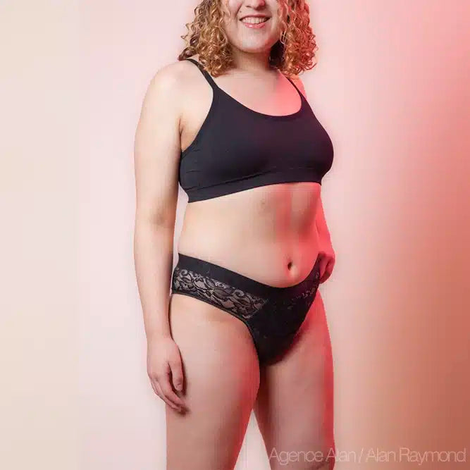 Tucking tanga BWYA Lace en noir, porté par un modèle, côté
